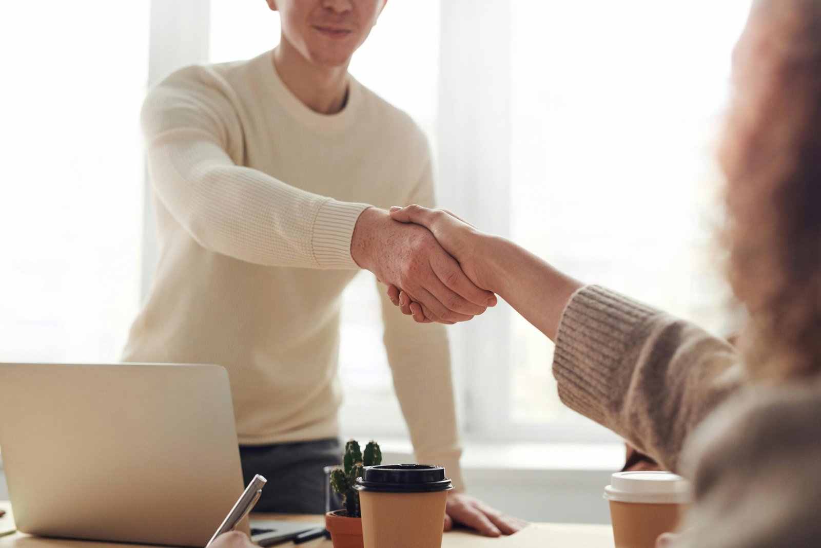 Lawyer shaking hands with client over desk, illustrating law firm lead generation and client acquisition
