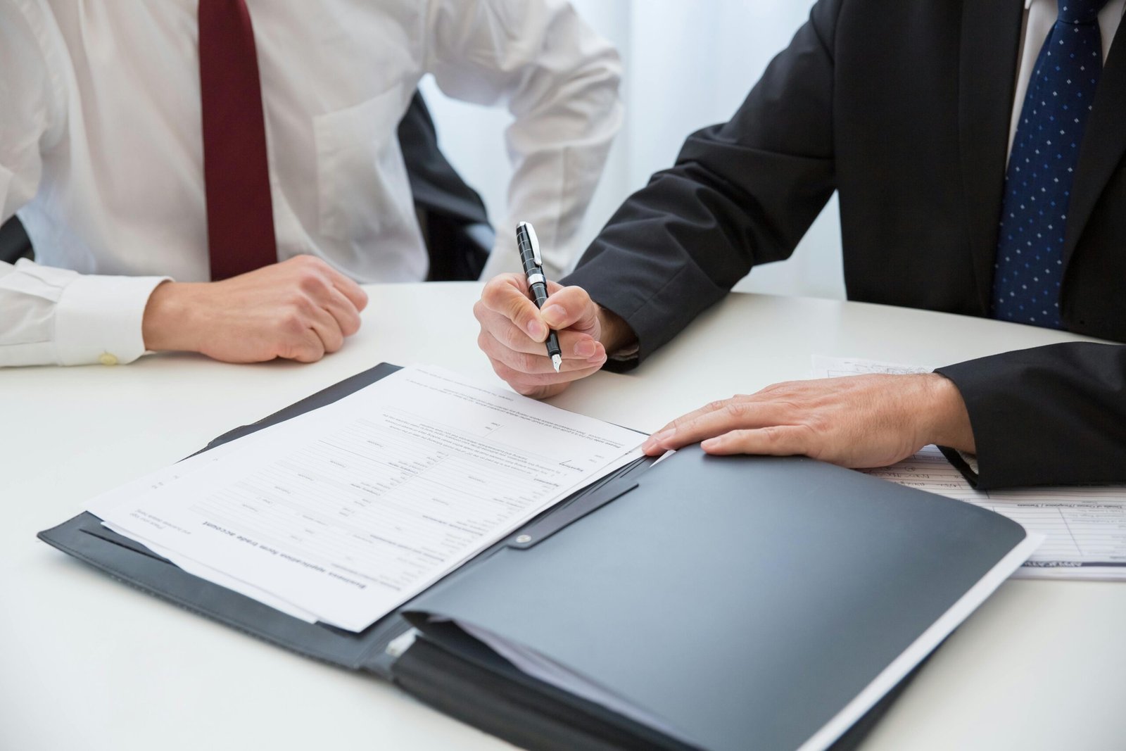 Lawyer at desk with client reviewing documents, representing law firm marketing and client growth
